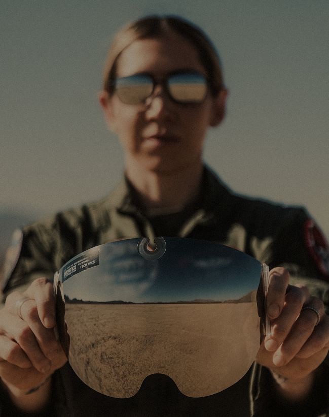 Thunderbirds pilot holding a reflective flight helmet visor while wearing Randolph Aviator sunglasses.